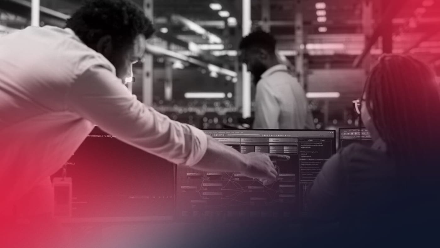 Profissional apontando para uma tela com fluxos e códigos em um ambiente industrial, representando processos de uma fábrica de software.