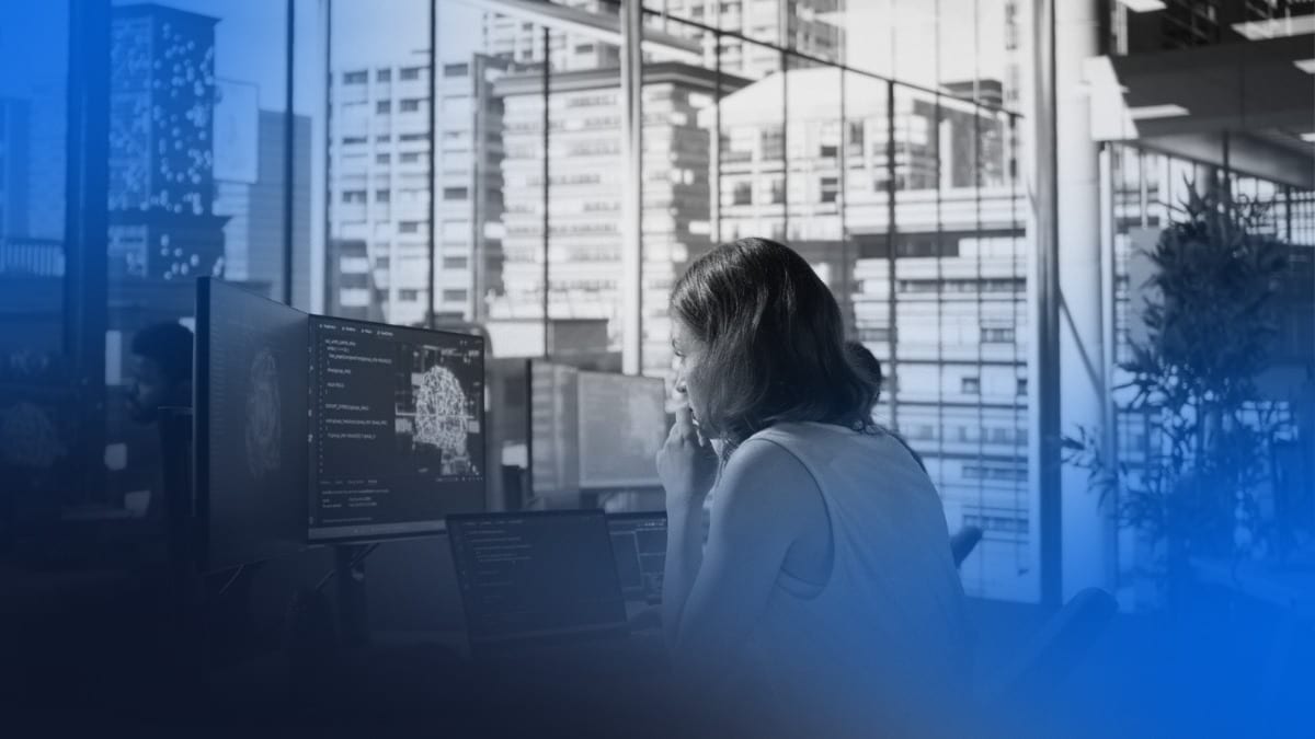 Profissional analisando dados em múltiplas telas em ambiente corporativo, ilustrando monitoramento financeiro e otimização de recursos com FinOps.