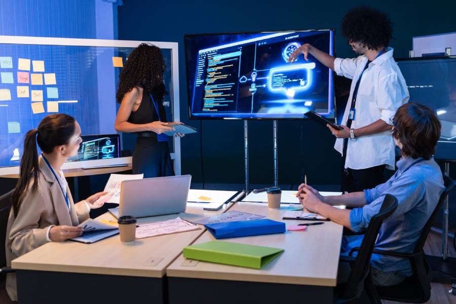 Equipe de tecnologia discute governança de IA em reunião, com painel digital exibindo fluxo de processos automatizados.