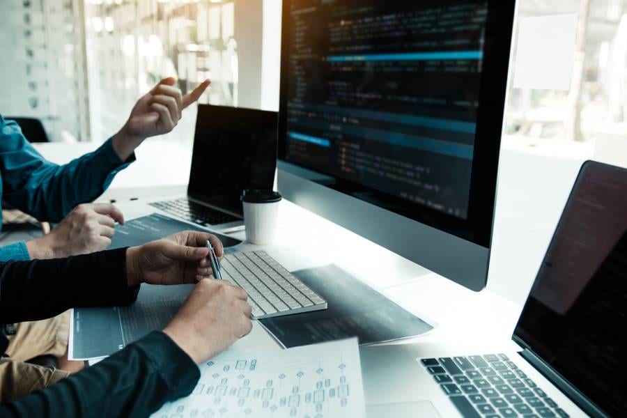 Equipe utilizando IA no desenvolvimento de software para análise de código e otimização de sistemas.