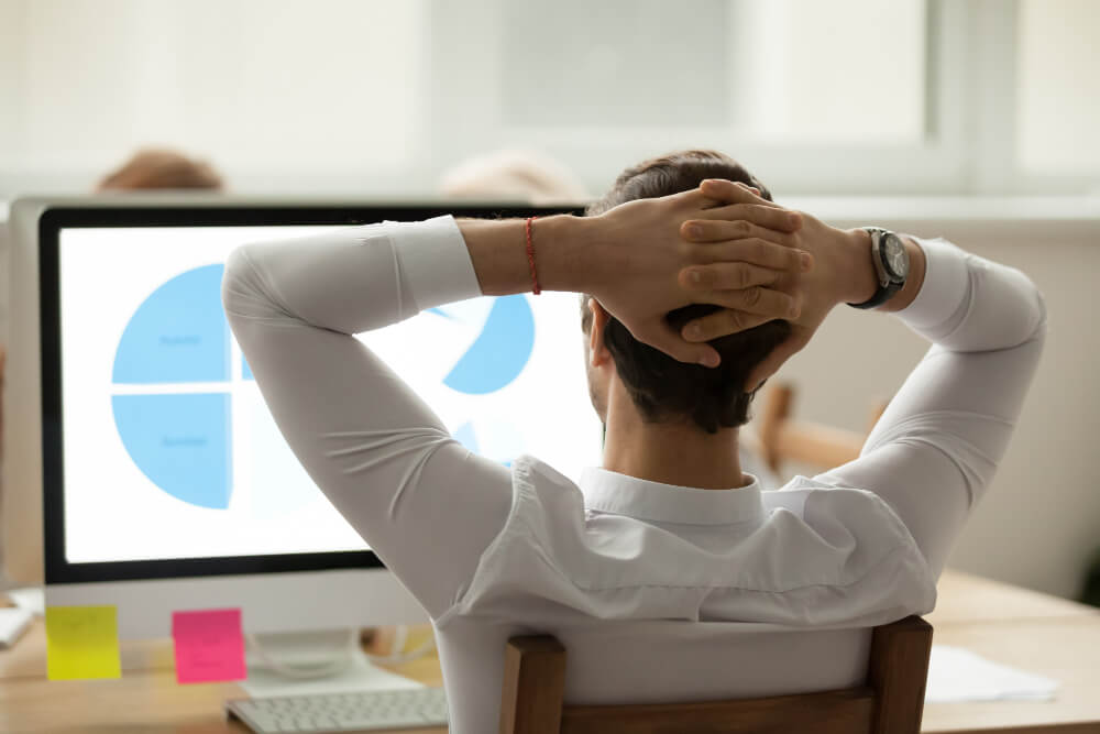 Pessoa frustrada diante de papéis amassados e anotações, representando o impacto do atraso em projetos de TI no cronograma de entregas.