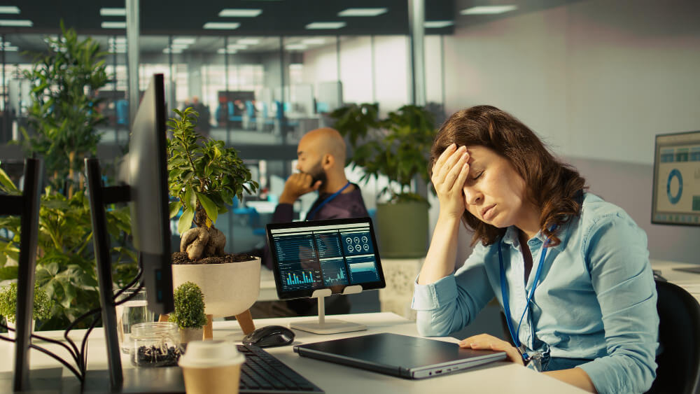 Profissional estressado diante do computador analisando falhas no ciclo de vida de software, simbolizando problemas em projetos de desenvolvimento.