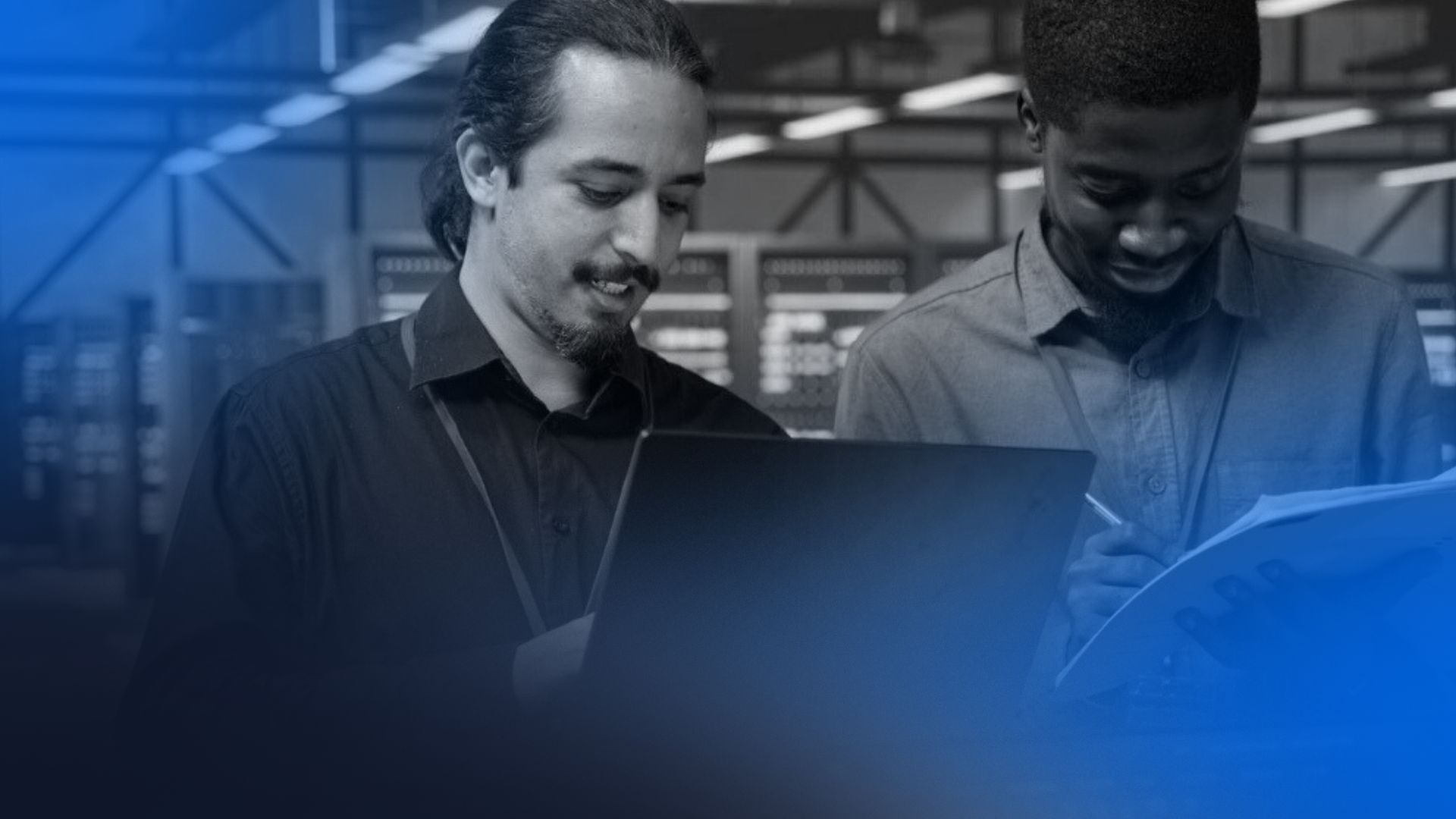 Especialistas de TI trabalhando de forma colaborativa com notebook e documentos, ilustrando o dia a dia de uma empresa de outsourcing de TI.